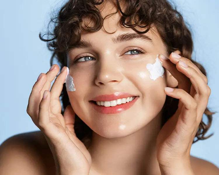 Radiant woman applying LumiEssence C Nourishing Cream for glowing skin.
